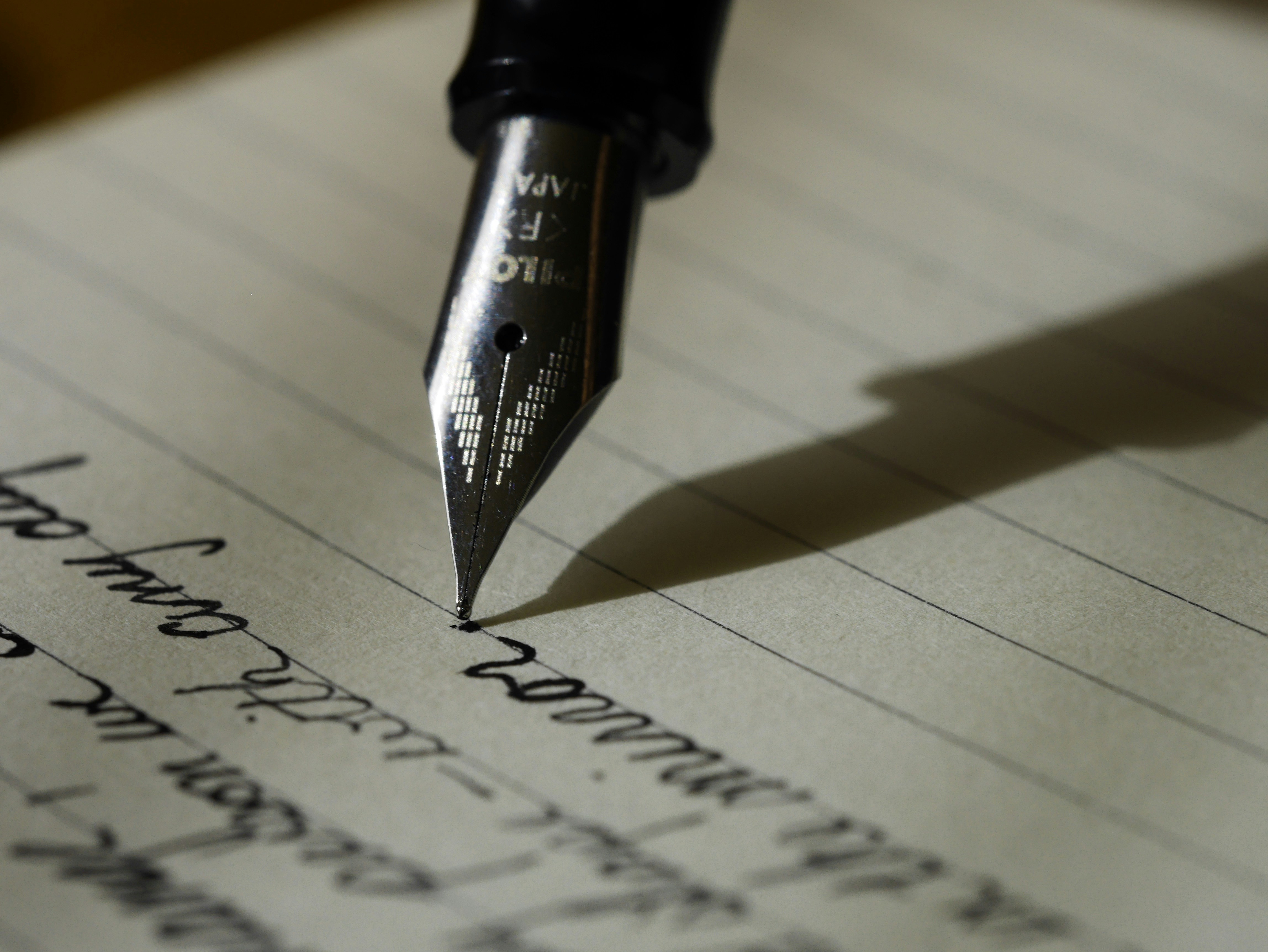 01M08SW2YP3NX99TPT2M70W3DE Closeup of a pen writing poetry